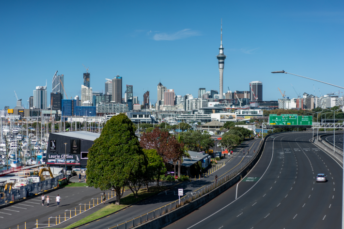 Auckland cityscape with view of Sky tower, motorway and the harbour, against clear blue skies
