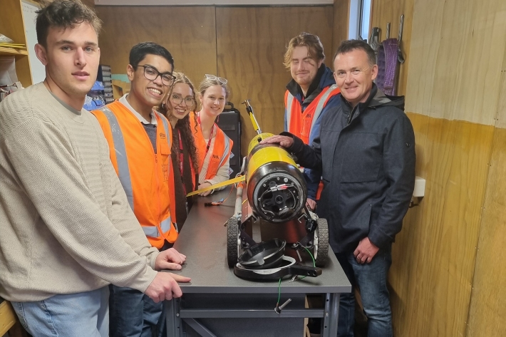 Joint grad school students with underwater research glider, Manaia