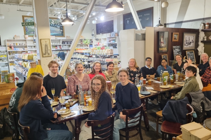 JGS students and staff seated around a restaurant table