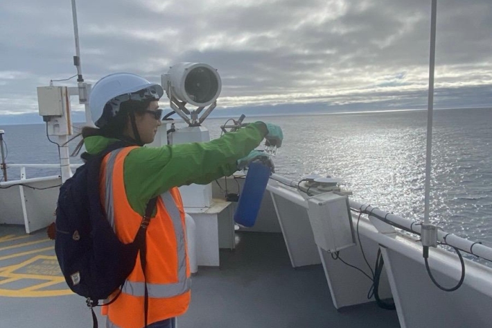 Hana Ishii collects an air flask sample atop Tangaroa