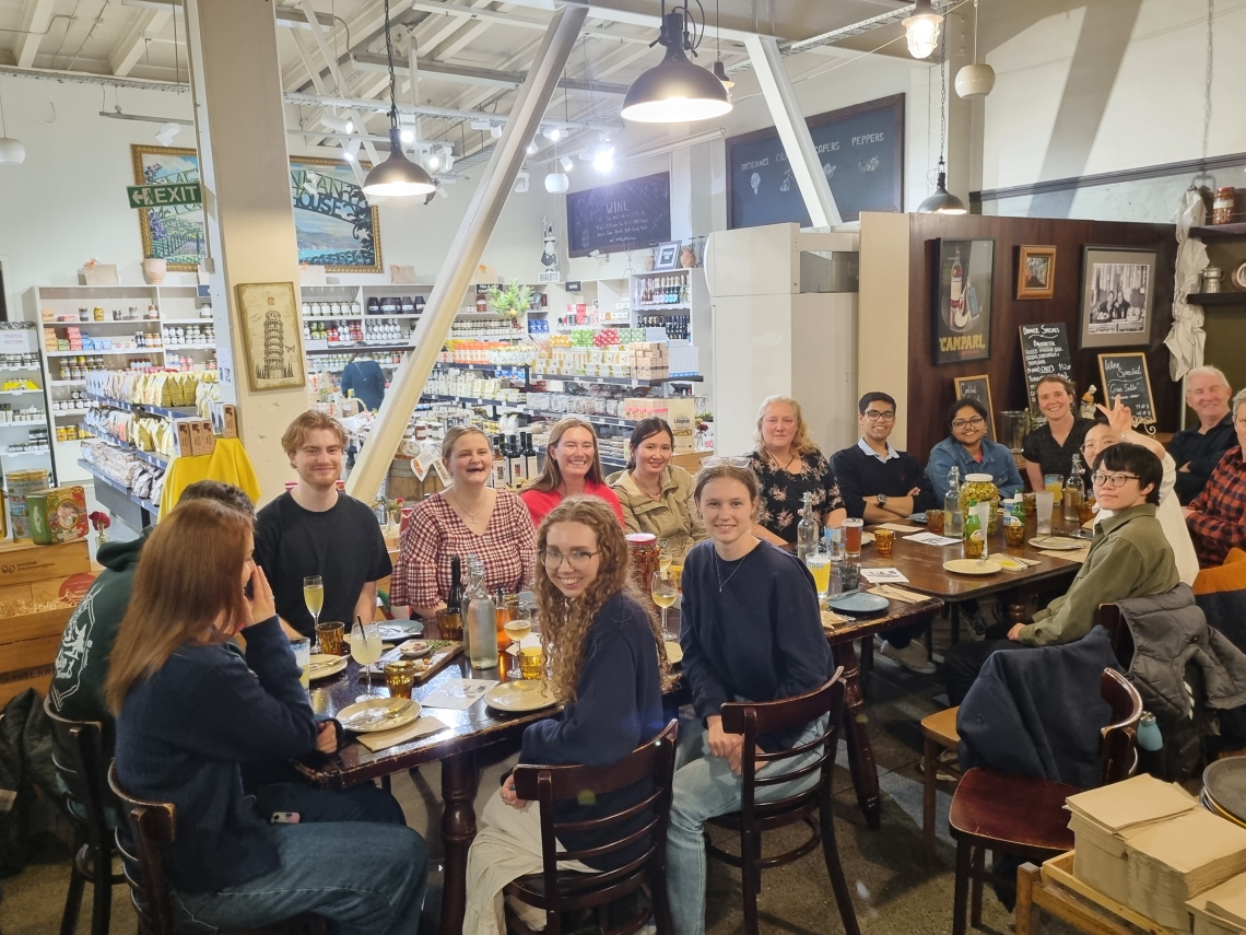 JGS students and staff seated around a restaurant table