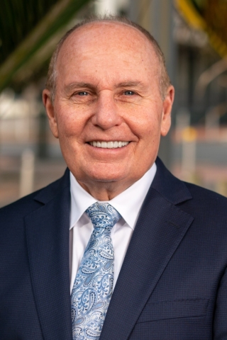 Headshot of John Morgan, Chief Executive, smiling in a suite and tie.