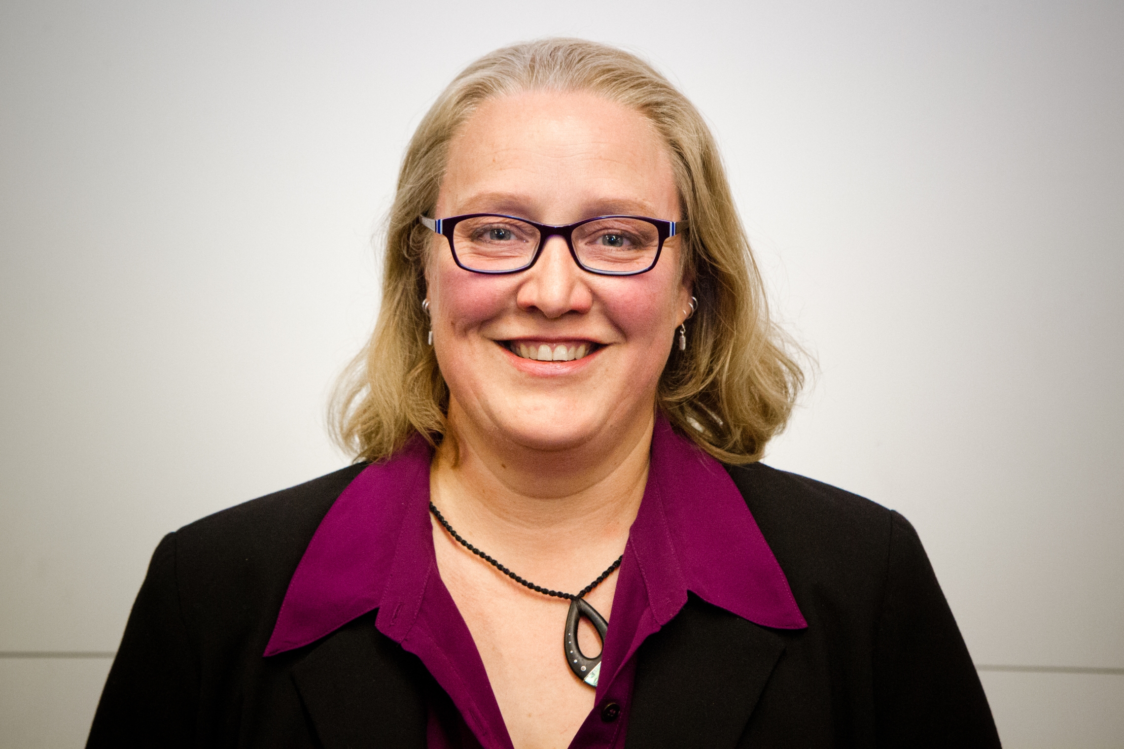 Headshot of Dr Carolyn Lundquist, smiling in business casual