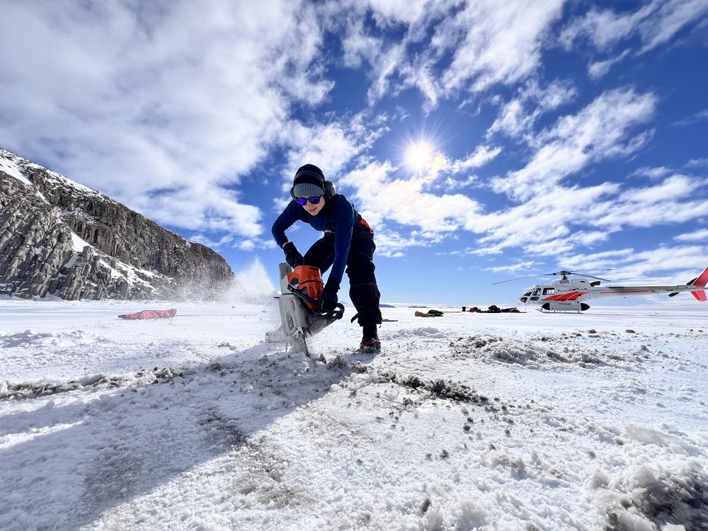 Sarah Seabrook cuts a whole in the ice with a chainsaw to access the ocean beneath.