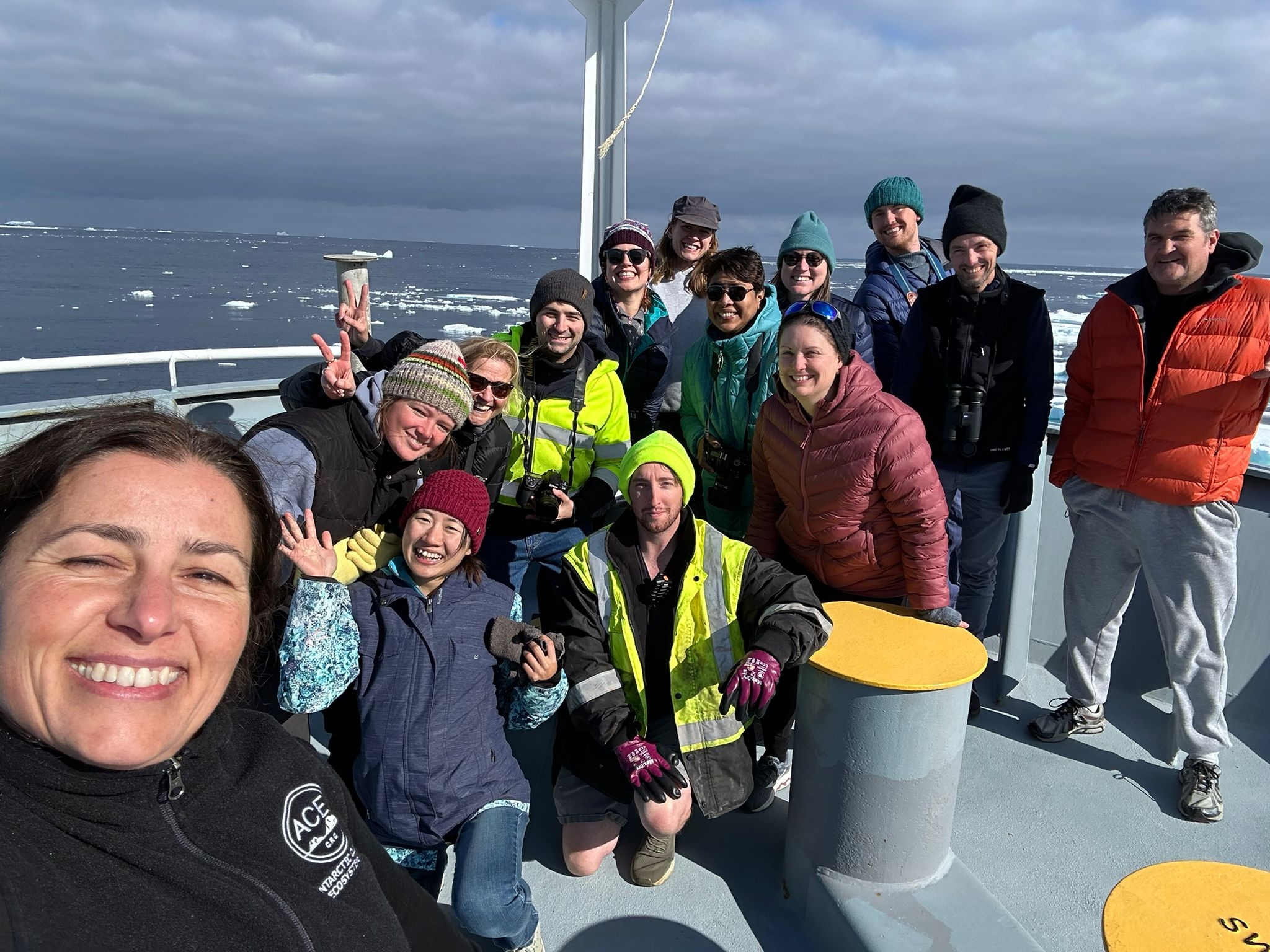 Some of the group gather on the bow for a photo with the sea ice
